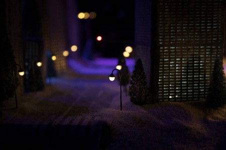 有道路和灯光的小型城市。冬天晚上在雪地里装饰可爱的小房子。创意度假理念。圣诞和新年属性装饰组成。
