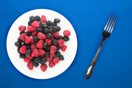  blackberry and raspberry on a white plate. blackberry and raspb