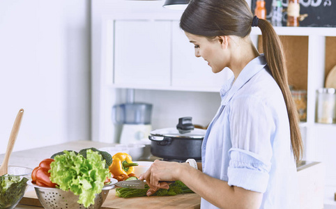一个年轻的女人在厨房里准备食物。健康食品蔬菜