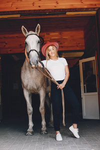 Elegant girl in a farm wiith a horse