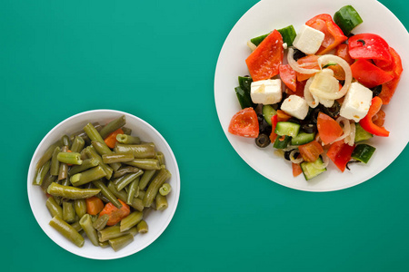  Greek salad on a colored background. Greek salad on a white pla