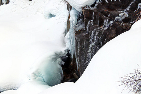 山涧流淌在岩石和岸边的白雪之间