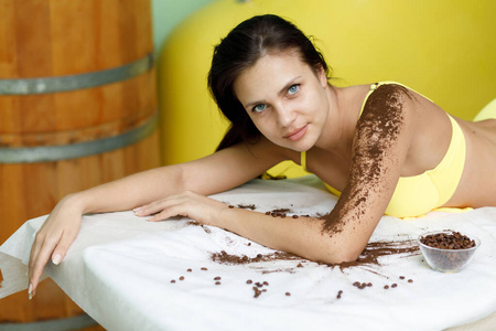 一位黑发女子在水疗沙龙接受咖啡擦洗治疗