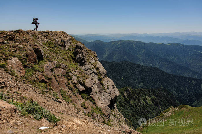 旅行者走到一座高山峭壁上
