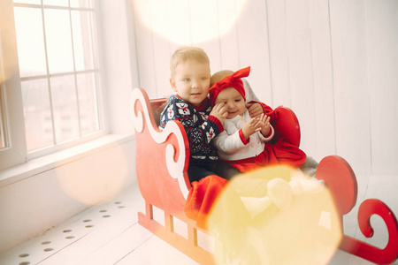 两个可爱的孩子坐在圣诞装饰品里
