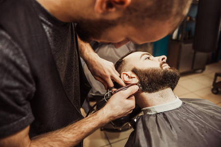 专业美发师为客户剪胡子。