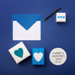 Blue envelope, gifts and white hearts on classic blue 