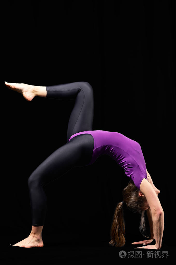 迷人自信的年轻健康健身女性在健身垫上锻炼瑜伽伸展黑色背景隔离