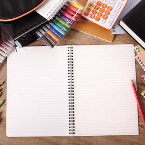 忙碌的学生桌上有空白的打开的笔记本