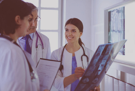 微笑的医生在医院里讨论病人在看x光片时的诊断