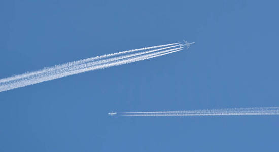 飞鹰巢的踪迹两架飞机在蓝天上飞行,引擎留下白色条纹.
