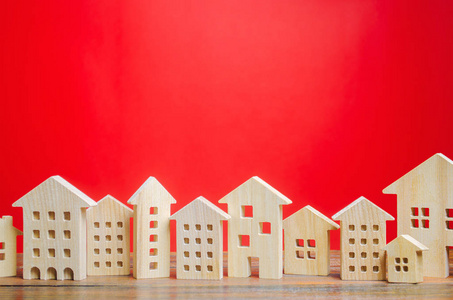 红色背景上的微型木屋。房地产概念。城市。集聚与城市化。市场分析。住房需求。房价的涨跌。人口。复制空间