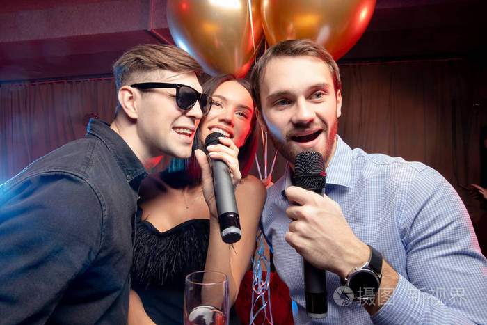 卡拉ok酒吧里快乐的高加索人在麦克风上唱歌的画像
