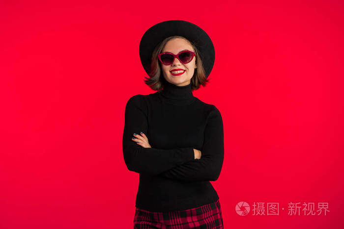 工作室里红色背景上年轻漂亮女人的肖像.