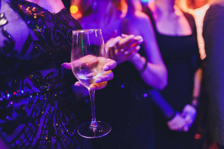 节日背景上拿着香槟酒杯的女人手.照片