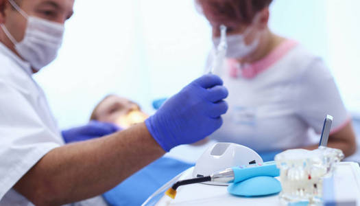 一位为年轻女性患者治疗牙齿的牙医肖像
