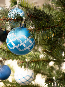 圣诞树树枝上挂着一个带装饰品的蓝色球。圣诞节和新年概念