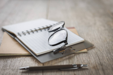 Selective focus of Pen, notebook, glasses on the table 