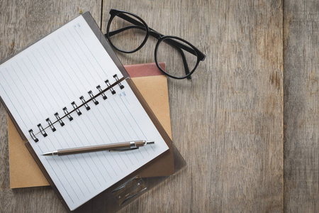 Top view of Pen, notebook, glasses on the table 