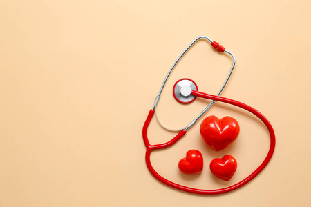 听诊器和红心色背景。心脏病学概念