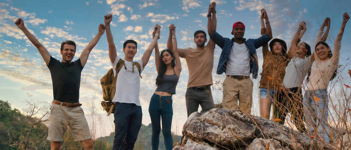 group of diversity people having fun together climbing up rocky 