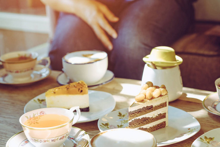 喝茶聚会快乐的女性朋友们下午在咖啡厅聚会,一起喝茶或喝咖啡,吃蛋糕