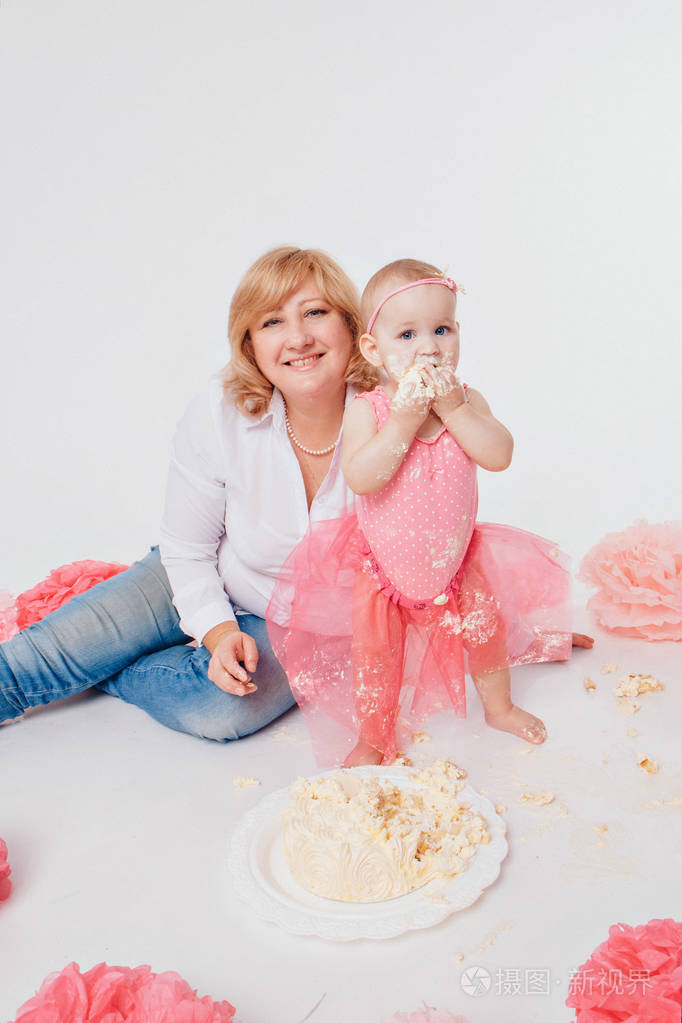 生日庆祝小女孩手放在白色背景上吃蛋糕孩子全身都是食物地板上的装饰