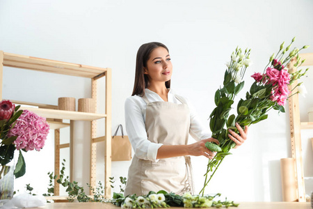 车间餐桌上摆出漂亮花束的花匠图片