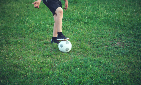 足球场上拿着足球的男孩。