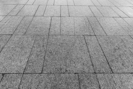 Top view on paving stone road. Old pavement of granite texture. 