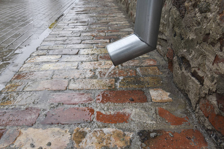 雨水从排水沟流出.照片