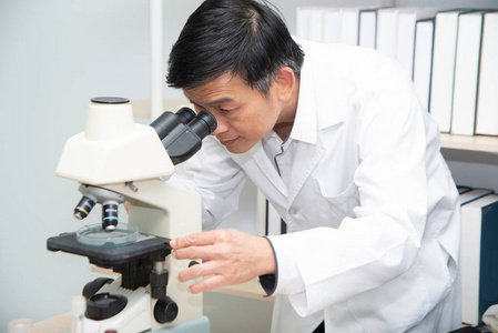 Scientist using Microscope in Laboratory. 