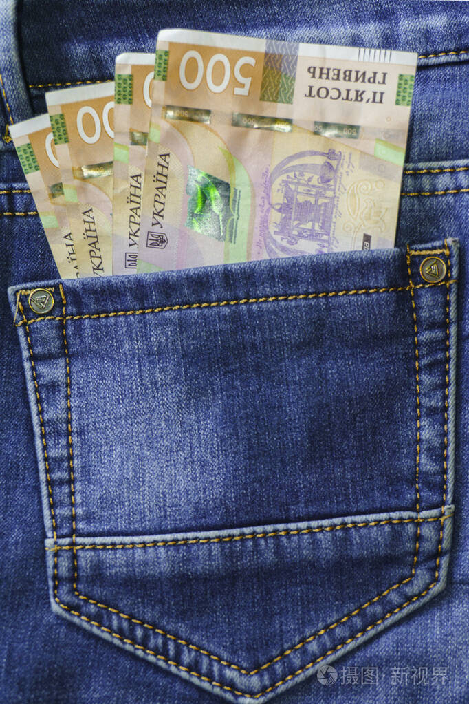 新的钞票五百格里夫尼亚钞票在蓝色牛仔裤的后口袋里.金钱观念,腐败.