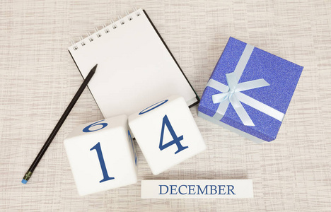 12月14日的立方体日历和礼品盒，旁边有一个铅笔笔记本