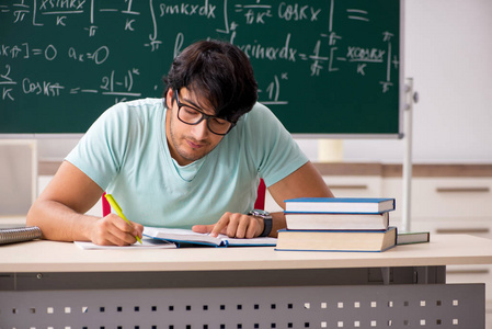 黑板前的年轻男学生数学家