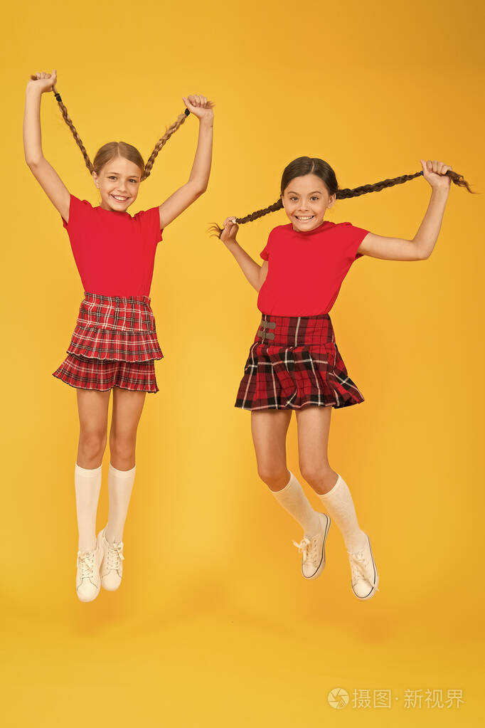 加入庆祝活动校服苏格兰风格快乐的朋友女生们跳着黄色的背景庆祝节日