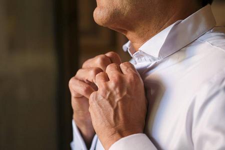  groom ties his shirt for his wedding