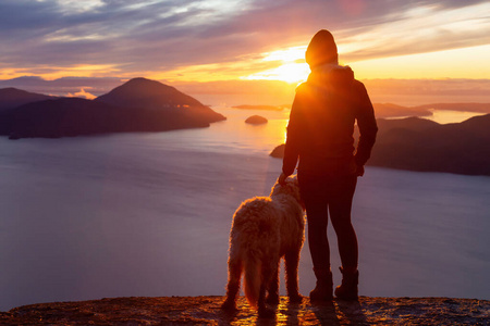 喜欢冒险的女孩和狗一起在山顶徒步旅行照片