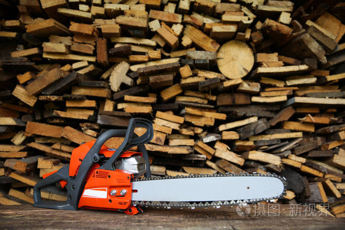  chainsaw is on sawn firewood background