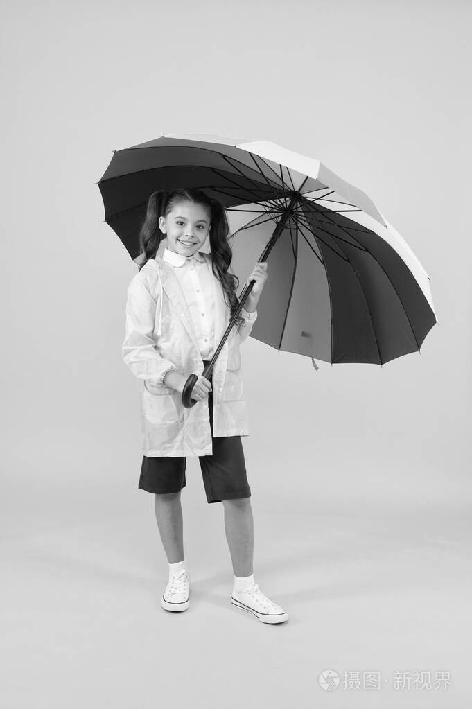 无忧无虑的女学生彩色雨伞穿防水雨衣.秋雨.