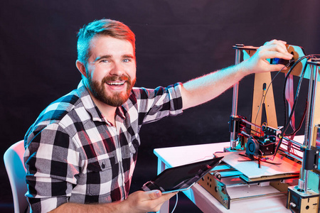年轻男性设计师工程师，在实验室使用3D打印机，研究产品原型技术和创新理念