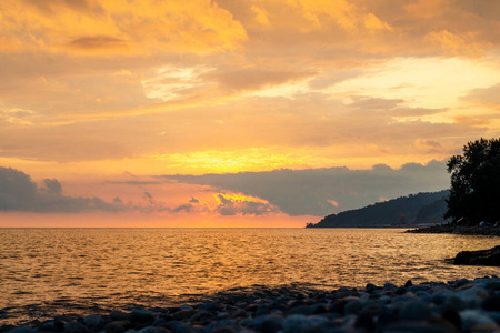 夕阳下橙色的天空。在海滩上挥手