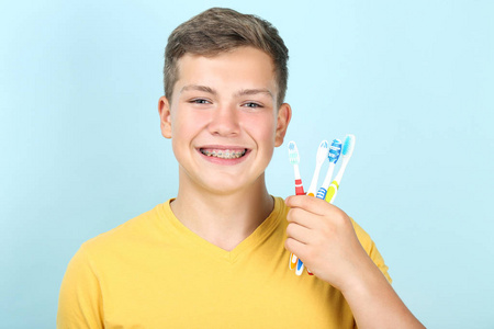 一个拿着蓝色背景牙刷的年轻人