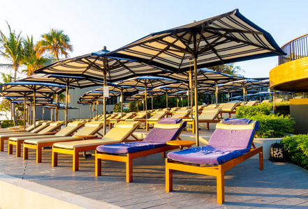 bedpool with umbrella around swimming pool in hotel resort 