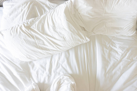 床上铺着毯子的白色枕头