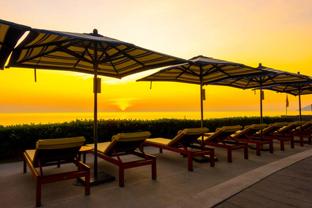 umbrella and chair around outdoor swimming pool in hotel resort 