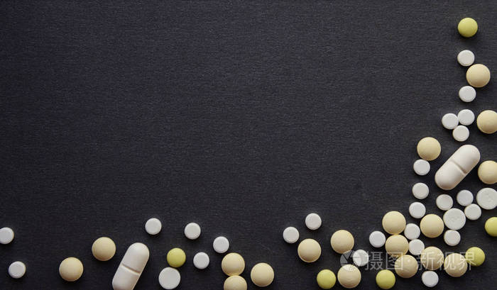 药理学各种药丸片剂和胶囊深灰色背景上的不同颜色的白黄色平板带复制