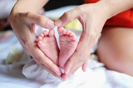 Parent holding in the hands feet of newborn baby. 