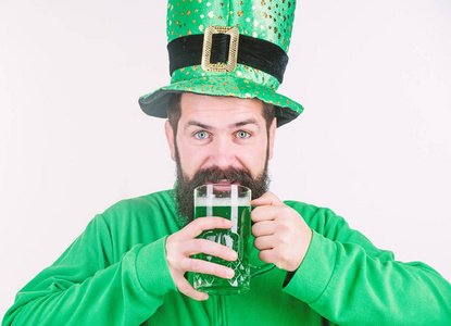 爱尔兰酒吧。酒精消费是圣帕特里克节不可或缺的一部分。爱尔兰文化。男人胡子时髦有趣的帽子喝品脱啤酒。干杯概念。彩色绿色啤酒。青啤是
