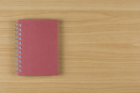 木制桌子上的红色笔记本。
